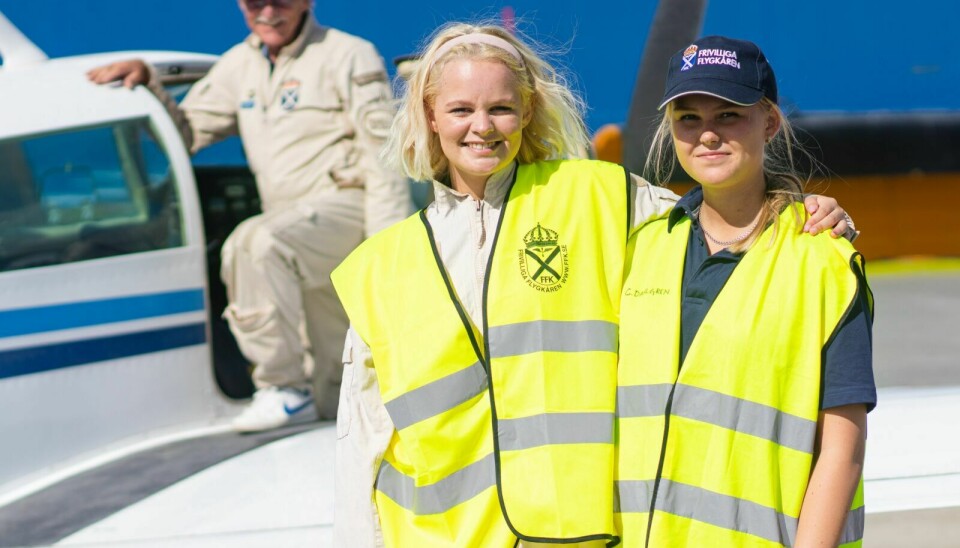 PILOTER: Cecilia Berg, til venstre, og Elsa Kärvestedt er muligens to framtidige, svenske piloter. Det hjelper i hvert fall på interessen å få en flytur fra Hedlanda til Røros. Ifølge Christer Dahlgren, som står i bakgrunnen, var det noe av poenget med turen. Foto: Morten Haugseggen