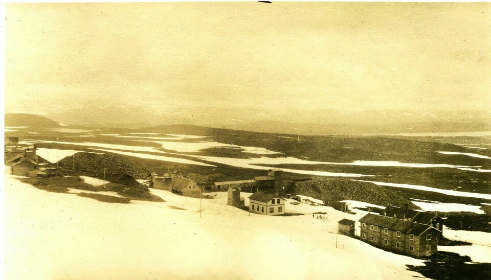 VÅRDAG PÅ KJØLI: Deler av bebyggelsen er nyere enn den Abraham Sandnæs opplevde. «Øverbyen» til venstre i bildet, «nedrebyen» til høyre. Riasten og Vigelfjellene skimtes i bakgrunnen. Bilde fra ca. 1920. Foto: NGU