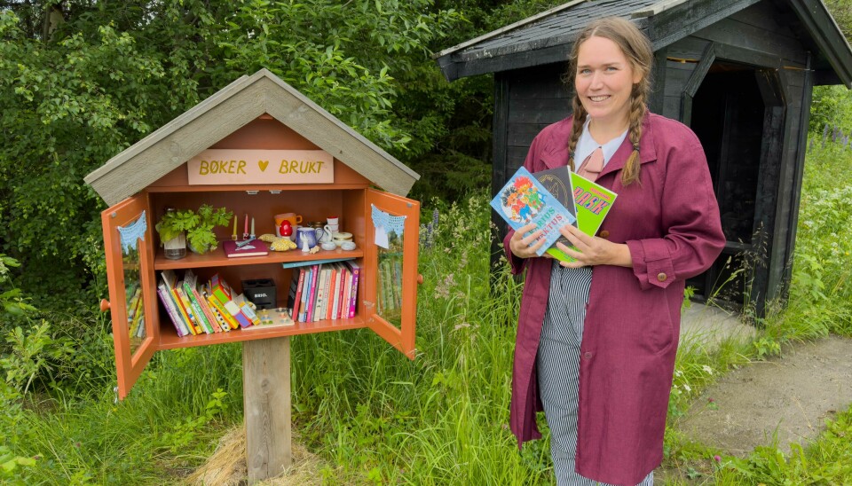 BIBLIOTEKAR: Paulien van Hoogen og familien har satt opp minibiblioteket langs Aunvegen i Haltdalen. Her er det bare å gi og ta.