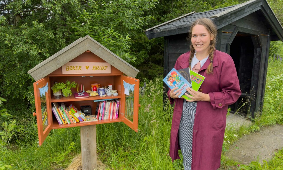 BIBLIOTEKAR: Paulien van Hoogen og familien satte opp minibiblioteket langs Aunvegen i Haltdalen i fjor sommer. Det er den lilla gjesteboka som på bildet ligger midt på øverste hylle som nå er savna.