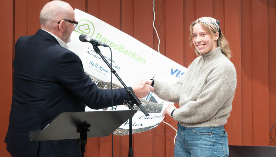 Nils Kåre Nesvold deler ut sjekk til vinner av skriverkonkurransen.