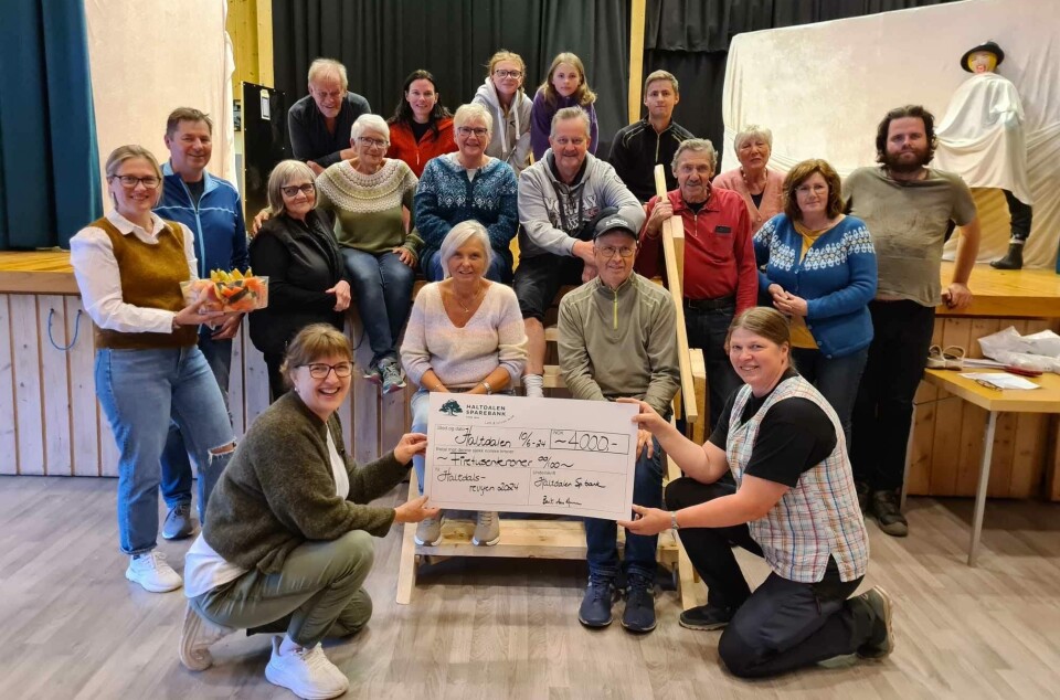 TILSKUDD: En glad gjeng i Haltdalsrevyen ble enda gladere da de ble overraska med frukt, brus og sjekk under kveldens øving mandag. Administrerende banksjef i Haltdalen Sparebank, Berit Aas Aune, til venstre med sjekken og leder i revygruppa Mari Bollingmo til høyre.