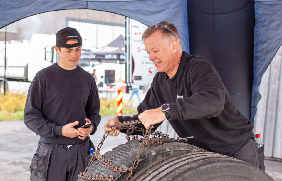 Elev Arnt Helge Frøseth Johansen observerer faglærer Terje Moan som setter ny bestenotering for dagen. 55 sekunder brukte han på å få kjettingen på plass rundt lastebildekket.