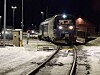 Persontog kjører inn på snødekt stasjon i mørket