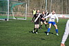 Kvinners fotballkamp på kunstgress, spillere løper mot ballen foran mål.