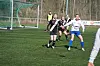 Kvinners fotballkamp på kunstgress, spillere løper mot ballen foran mål.