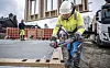 Bygningsarbeidere monterer prefabrikkerte treelementer på en betongplate på byggeplass.