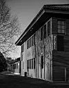 Svart-hvitt foto av en bygning med skiltet Ren Røros ved en tom gate og nakne trær.